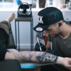 Bryan Du Rand freehand drawing the tattoo design on a client